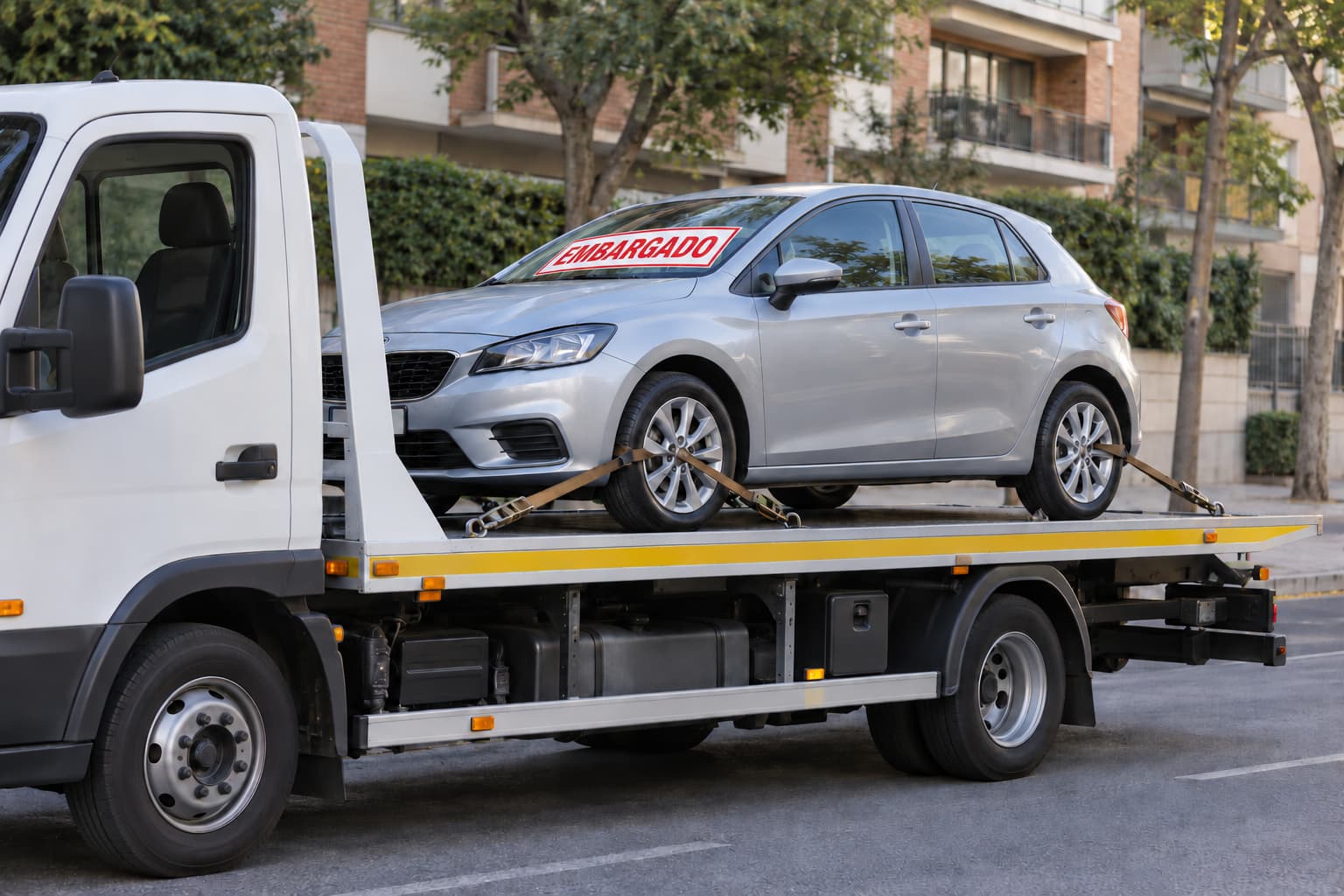 Coche embargado cargado en una grúa para su traslado